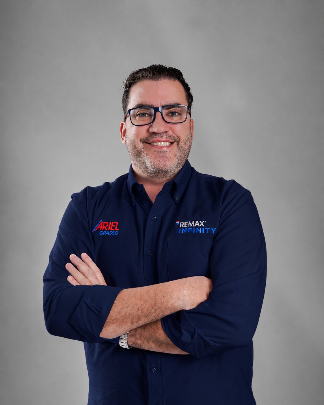 Retrato de Ariel Grasso con camisa azul oscuro de REMAX Infinity y los brazos cruzados