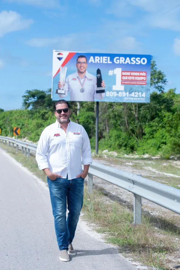 Ariel Grasso frente a una valla publicitaria de su marca
